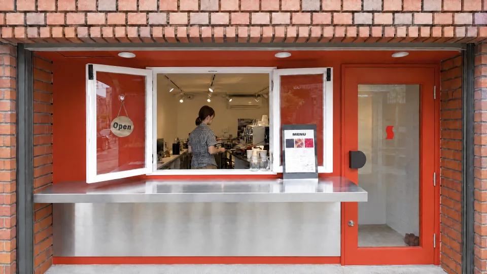 S/CAFEの赤い扉とレンガの外観